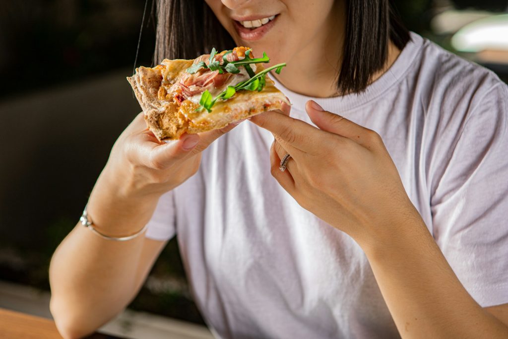 a woman is eating a piece of pizza